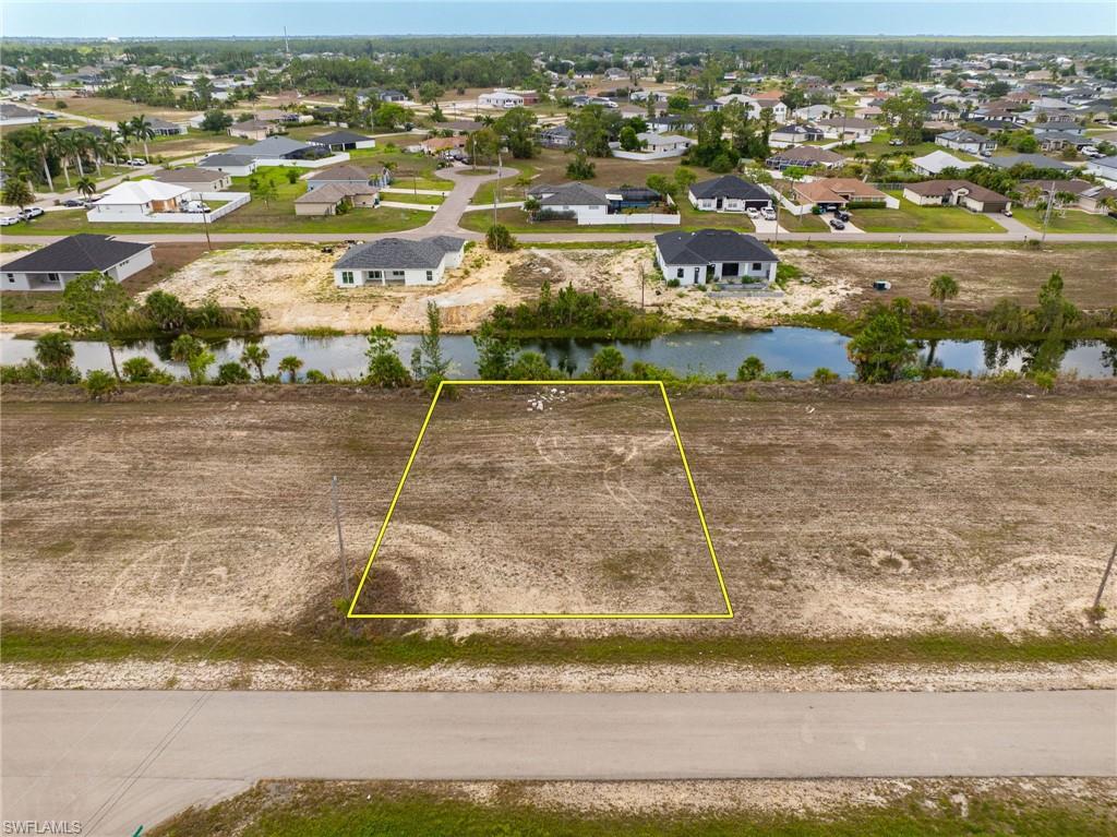 Aerial perspective of suburban area with a large body of water and property parcel outlined