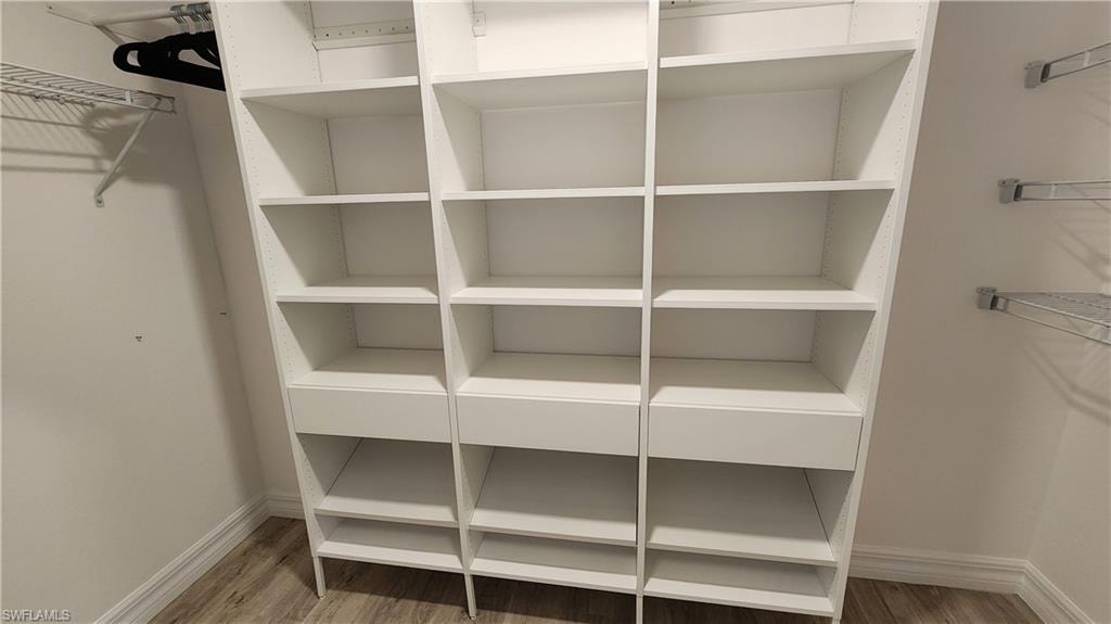 Walk in closet with wood finished floors