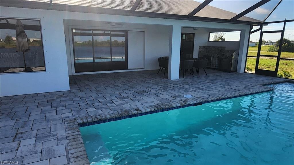 Swimming pool with a ceiling fan, a patio, a lanai, and outdoor dining area