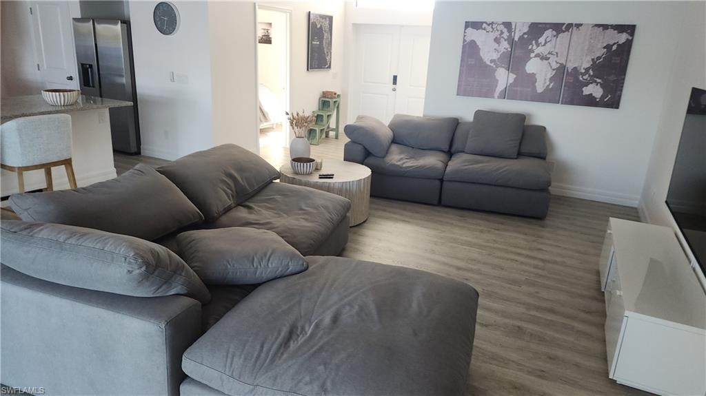 Living area with wood finished floors and baseboards