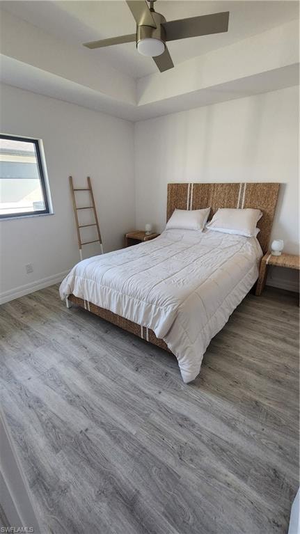 Bedroom featuring wood finished floors, ceiling fan, and baseboards