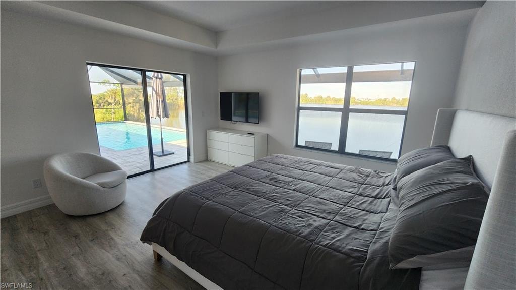 Bedroom with access to outside, wood finished floors, and baseboards