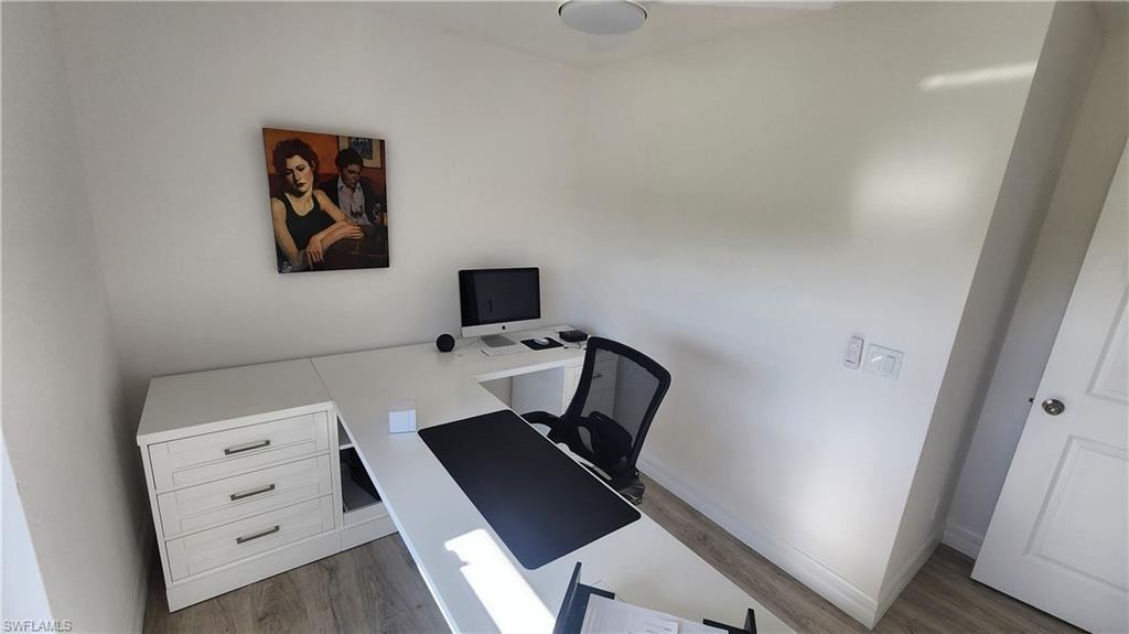Home office with wood finished floors and baseboards
