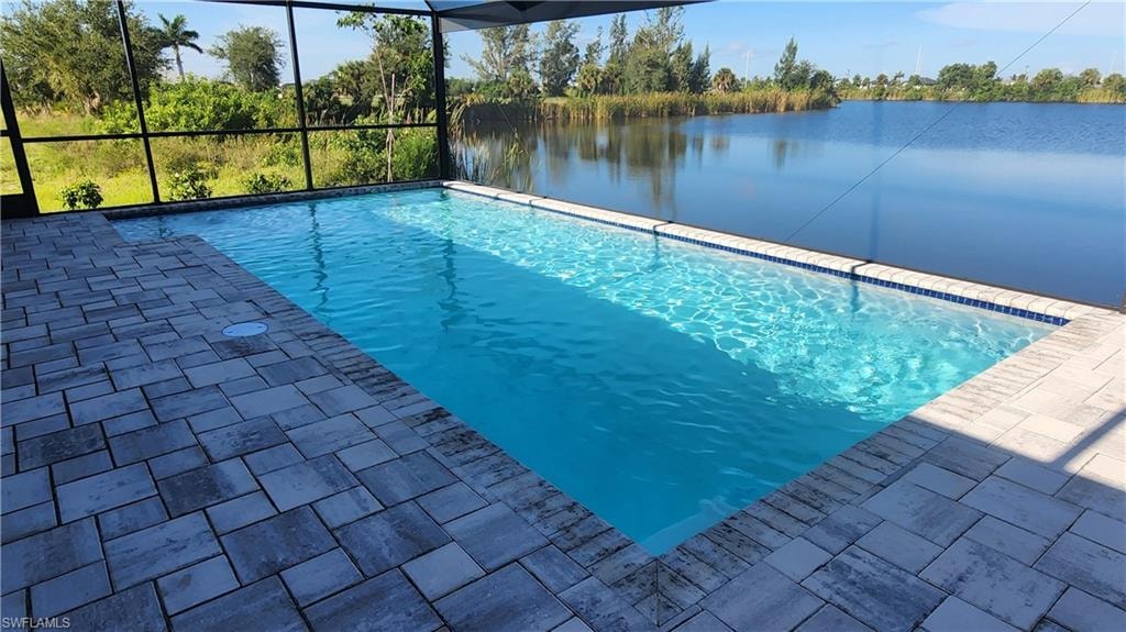 Swimming pool featuring a water view, a lanai, and a patio area