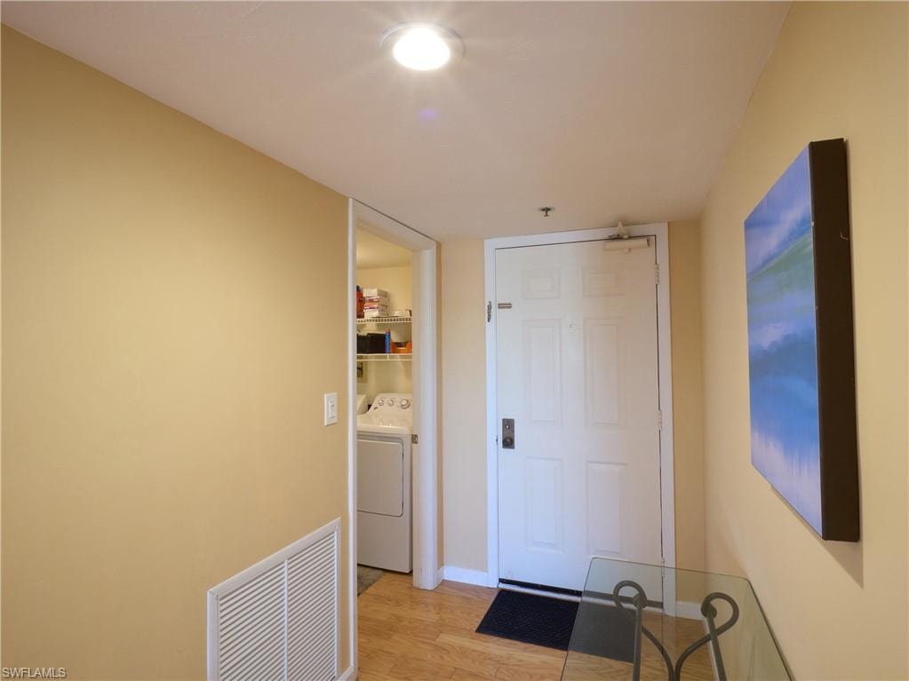 Corridor with light wood-type flooring and baseboards