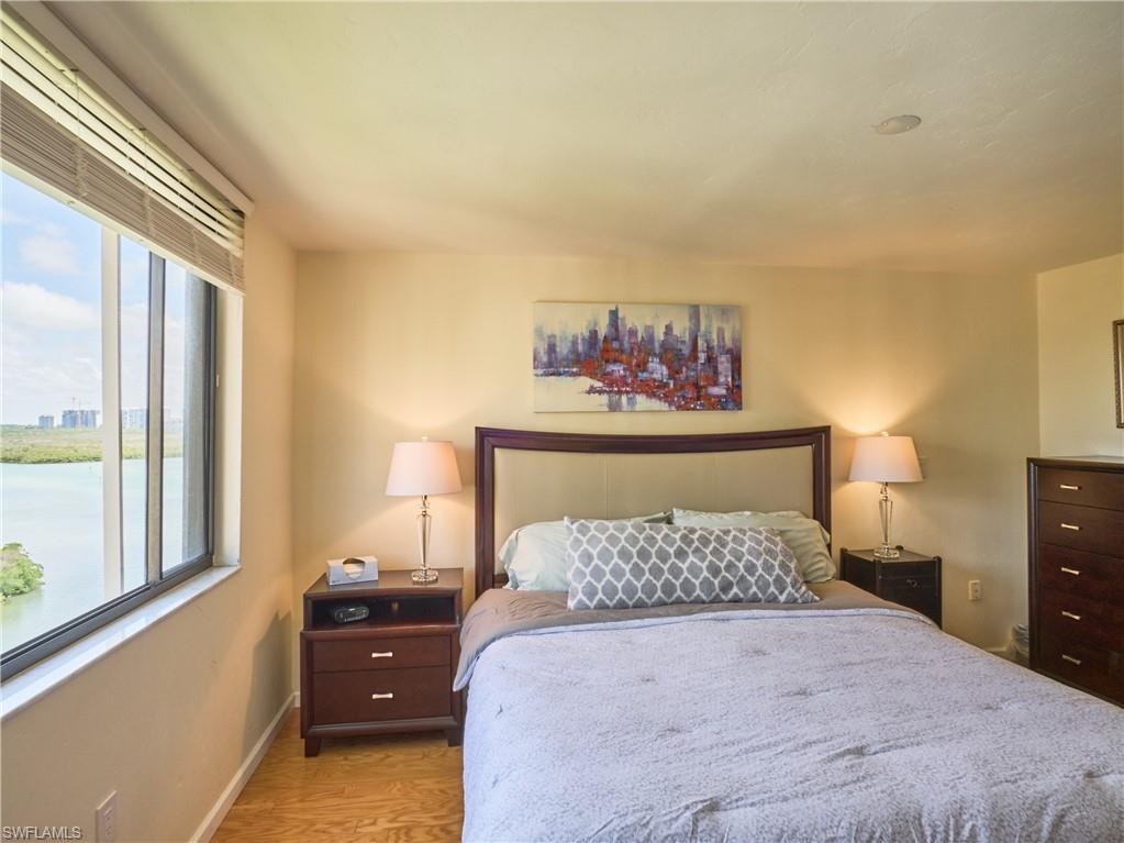 Bedroom featuring multiple windows, wood finished floors, and baseboards