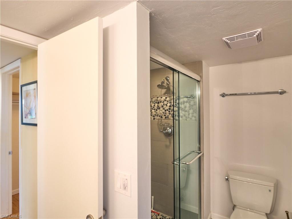 Bathroom with a shower stall and toilet