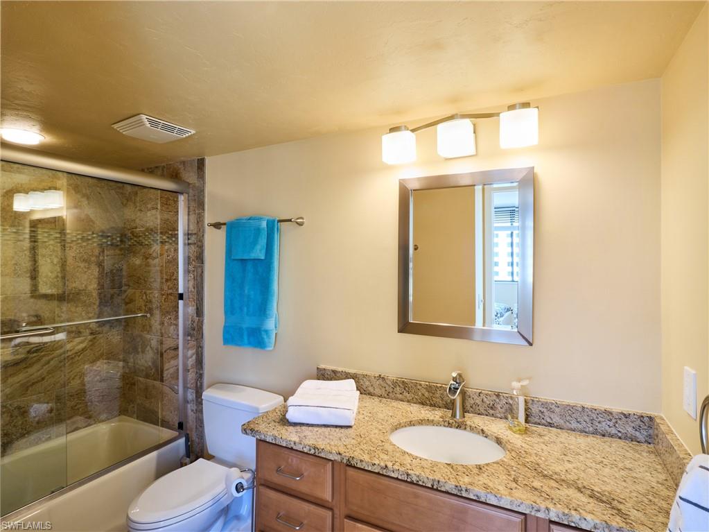 Full bathroom with vanity, toilet, and shower / bath combination with glass door