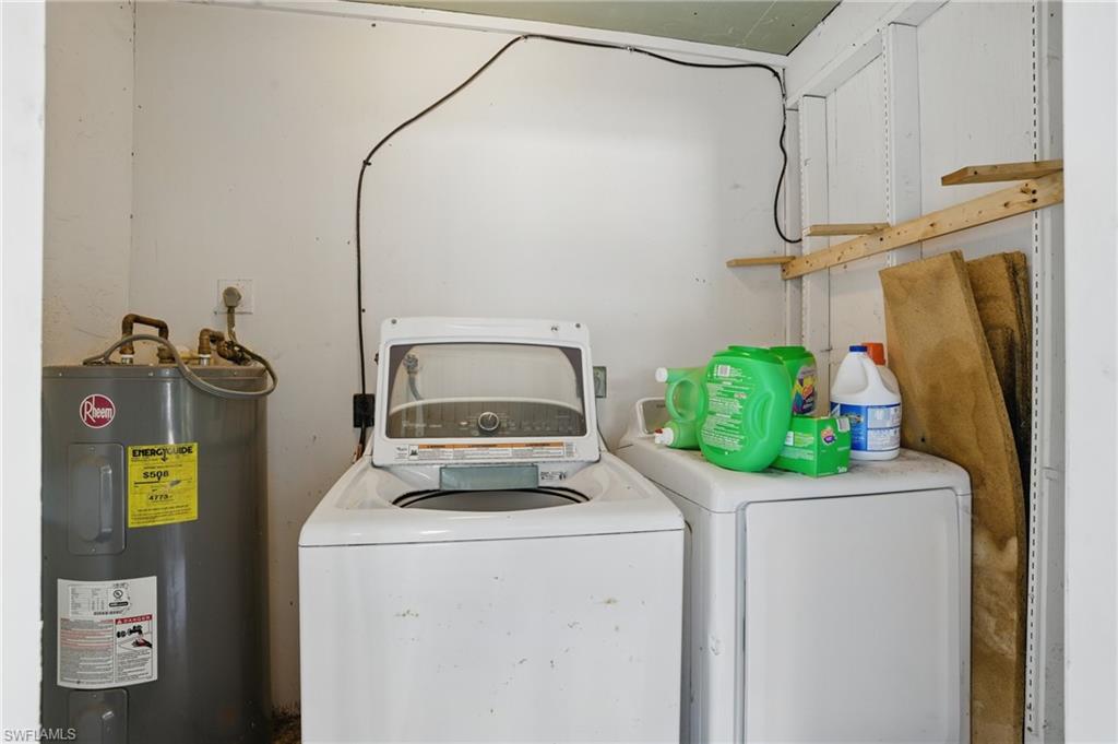 Washroom featuring water heater and separate washer and dryer