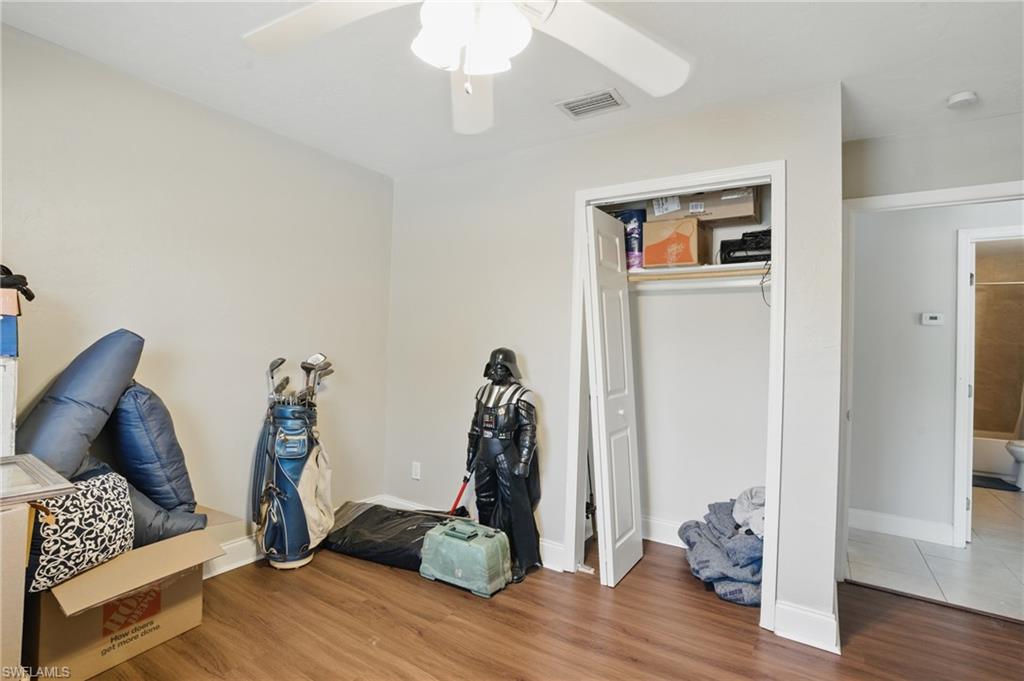 Bedroom with wood finished floors, ceiling fan, a closet, and baseboards