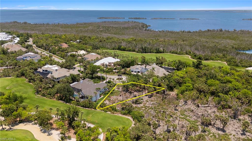 Aerial view of residential area with a golf course and a nearby body of water