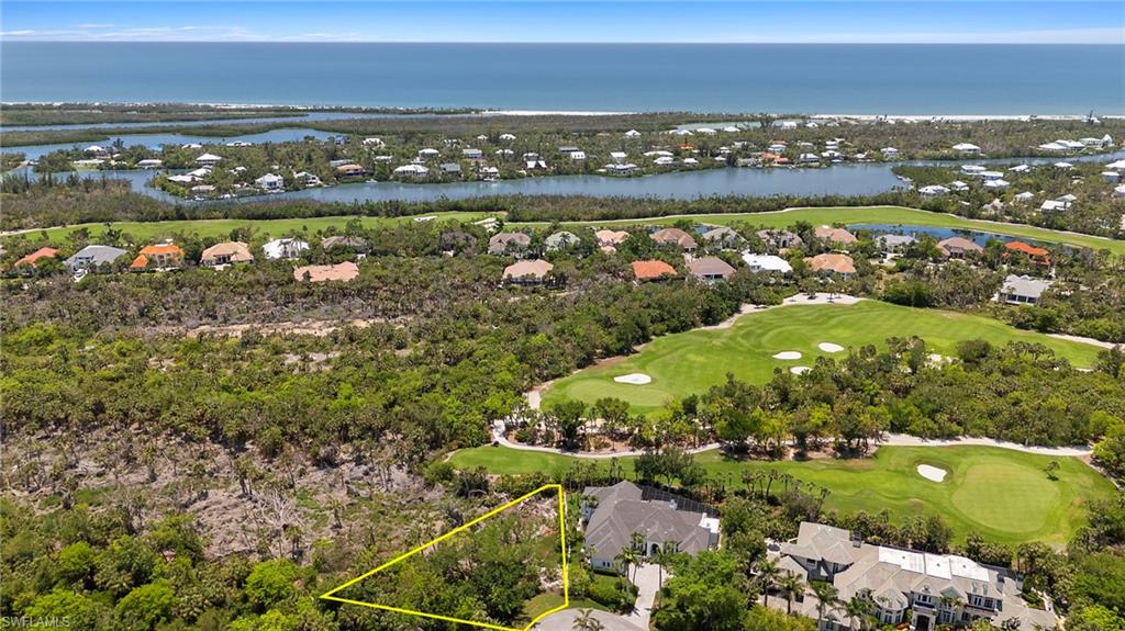 Aerial perspective of suburban area with a golf club, a nearby body of water, and property boundaries highlighted