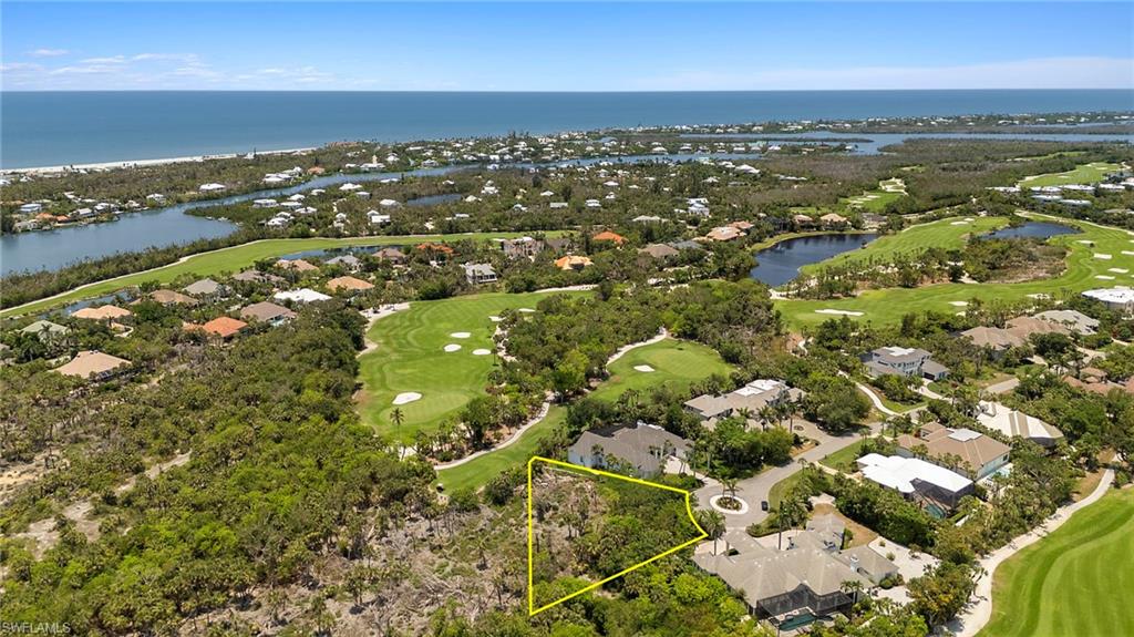 Aerial view of residential area featuring a golf club, a nearby body of water, and property boundaries highlighted