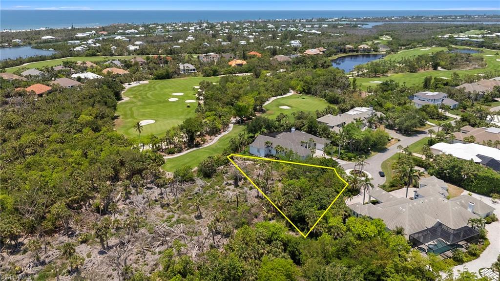 Aerial perspective of suburban area featuring a local golf course, a large body of water, property parcel outlined, and a tree filled landscape