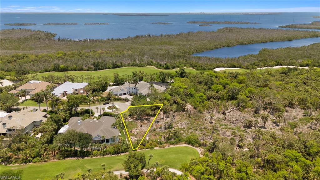 Aerial view of residential area featuring a large body of water, a golf club, and property boundaries highlighted