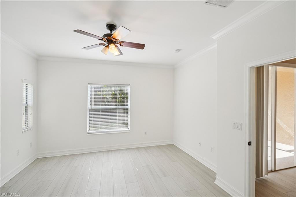Unfurnished room with ornamental molding, a ceiling fan, and light wood-style floors