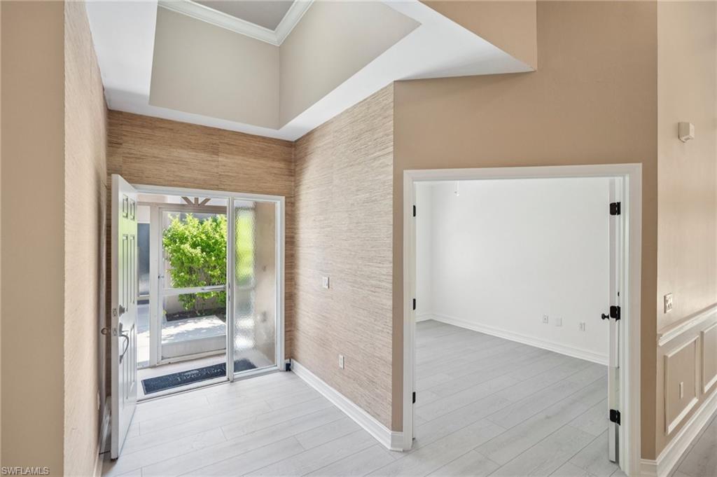 Entrance foyer with ornamental molding and light wood finished floors