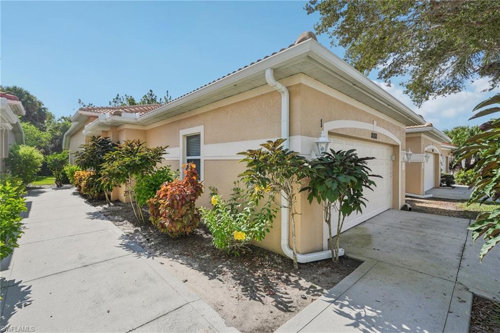 View of home's exterior with an attached garage, stucco siding, concrete driveway, and a tiled roof