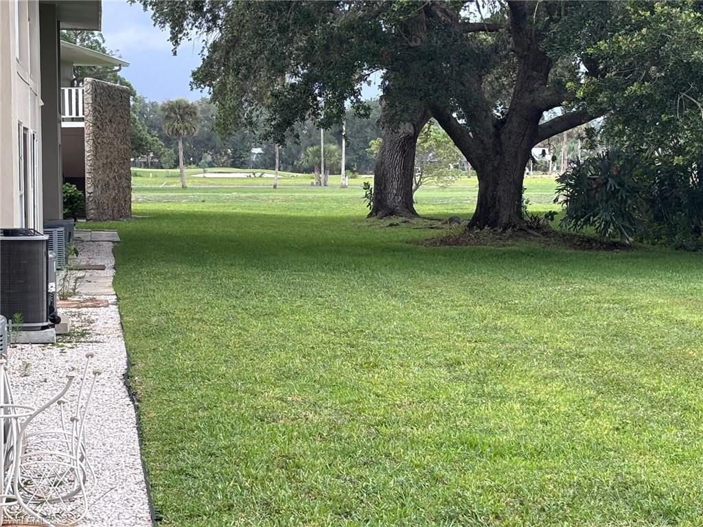 View of grassy yard featuring central air condition unit