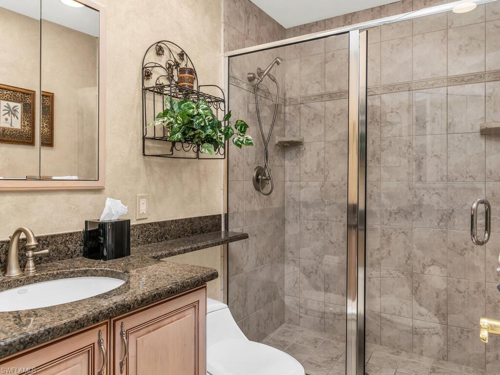 Bathroom with vanity, toilet, and a shower with door