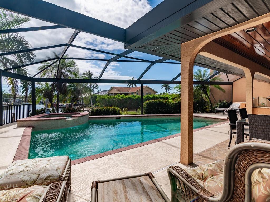 View of swimming pool with a lanai, a patio area, and an in ground hot tub