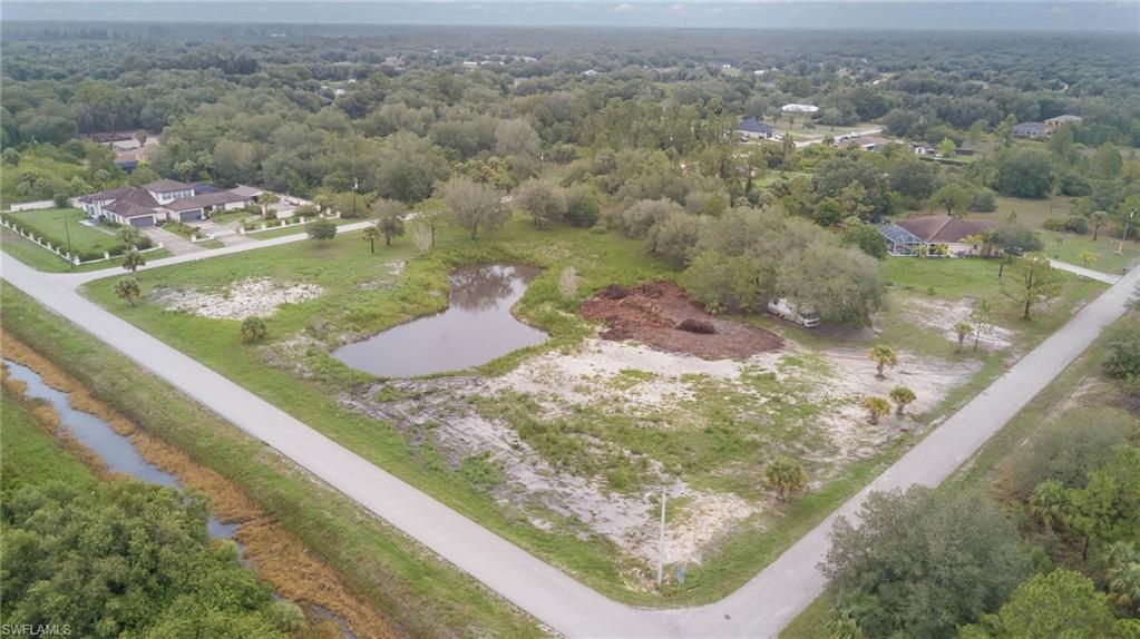 Aerial view of property's location with a nearby body of water and a heavily wooded area