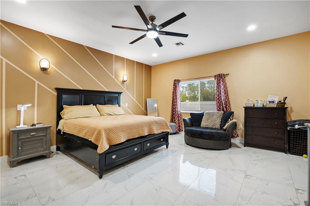 Bedroom with light marble finish flooring, ceiling fan, baseboards, and recessed lighting