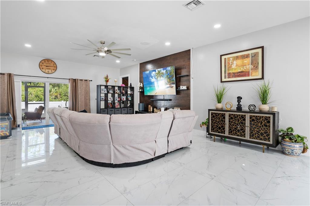 Living area with marble tiled flooring, recessed lighting, and a ceiling fan