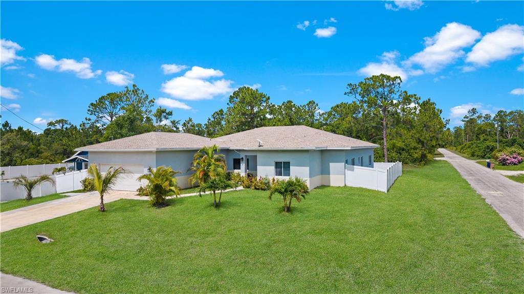 Single story home featuring a garage, concrete driveway, and stucco siding