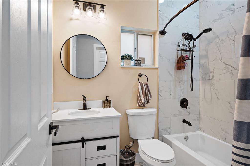 Full bath featuring vanity, shower / tub combo, and toilet