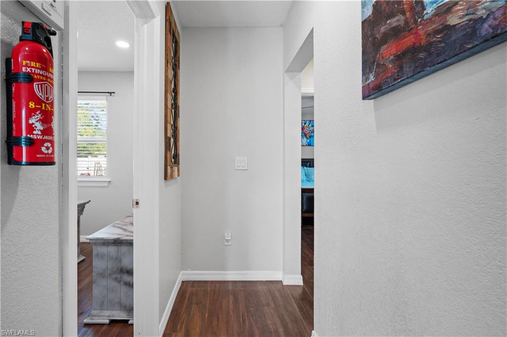 Hall featuring wood finished floors, baseboards, and recessed lighting