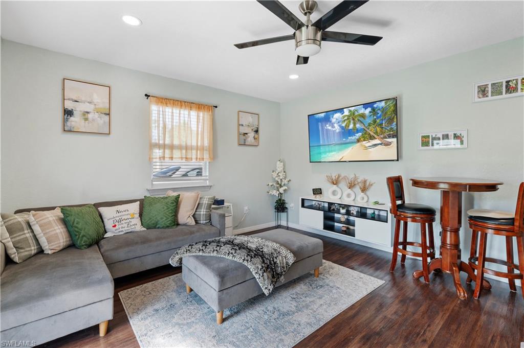 Living area featuring wood finished floors, a ceiling fan, recessed lighting, and baseboards