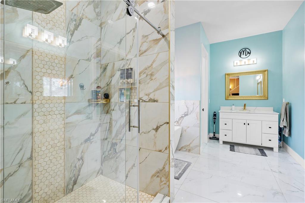 Full bathroom with vanity and a marble finish shower