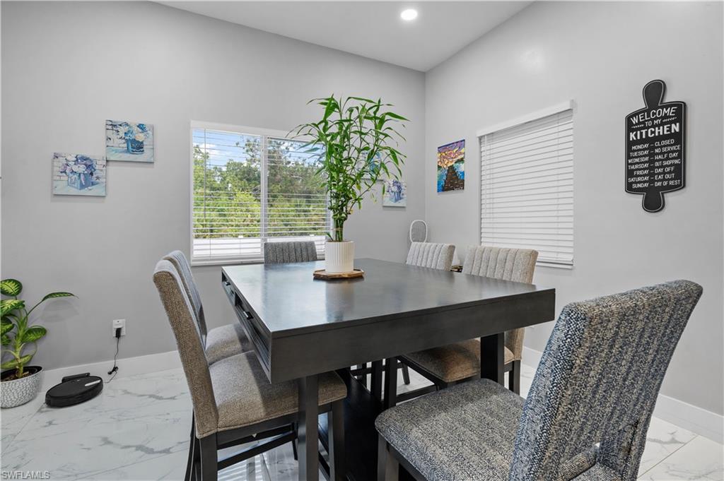 Dining room featuring light marble finish flooring, baseboards, and recessed lighting