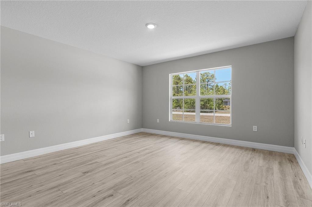 Unfurnished room featuring light wood-style floors and baseboards