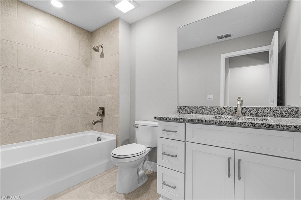 Full bath featuring toilet, shower / tub combination, vanity, and tile patterned floors