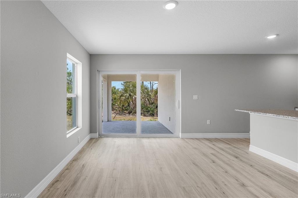Spare room with light wood-style floors, baseboards, and recessed lighting