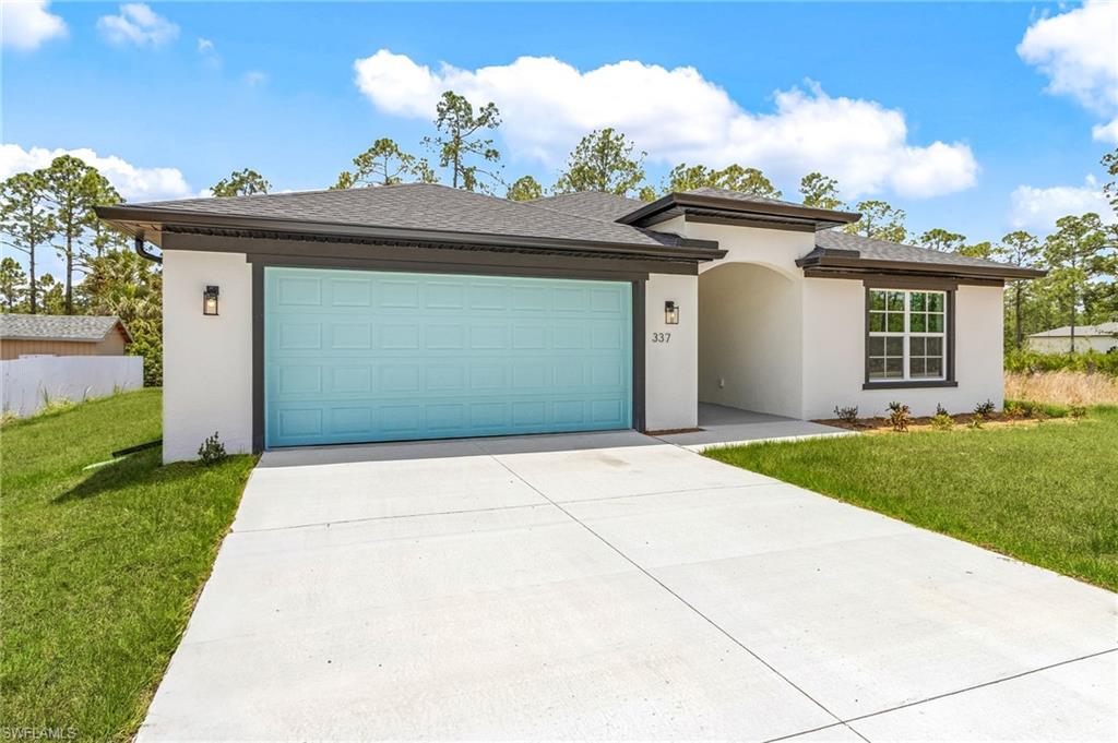 View of front of property with stucco siding, concrete driveway, and a front lawn