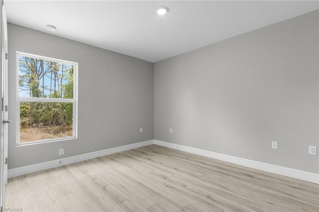 Spare room featuring light wood-style floors, baseboards, and recessed lighting