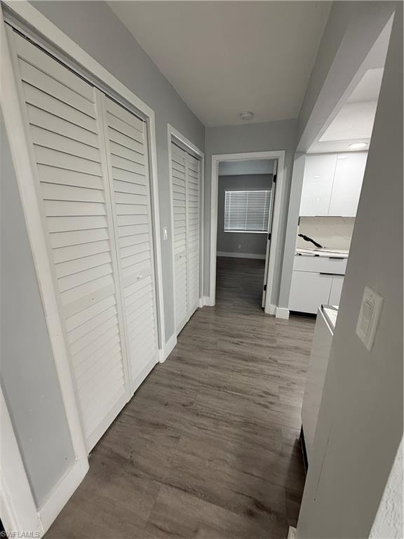 Hall with dark wood finished floors and baseboards