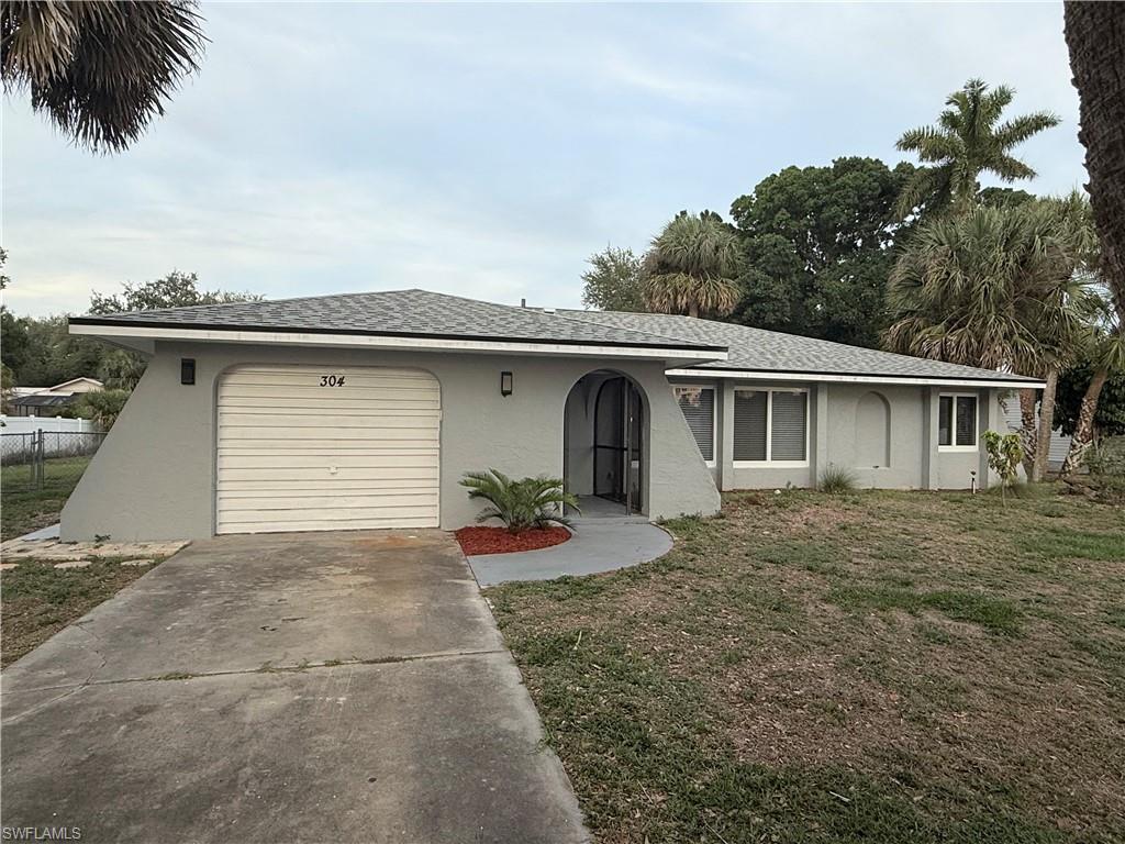 View of front facade with stucco siding, a garage, and concrete driveway