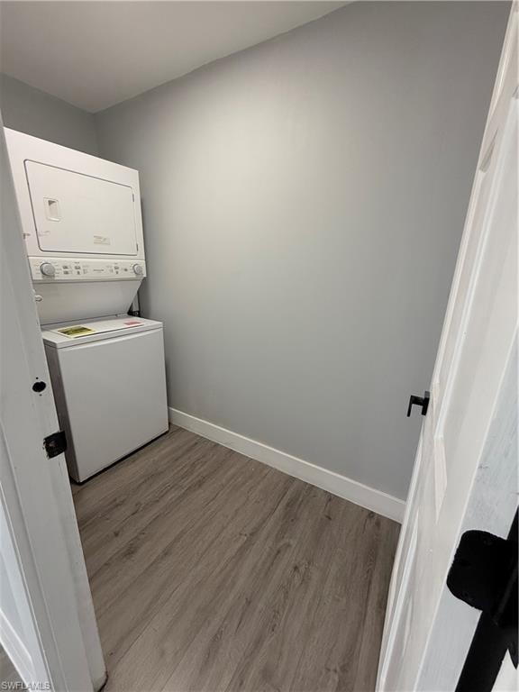 Laundry area featuring estacked washer and dryer and wood finished floors