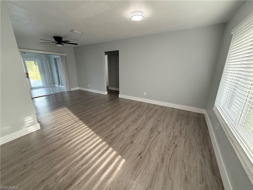 Unfurnished room featuring dark wood-style floors and a ceiling fan