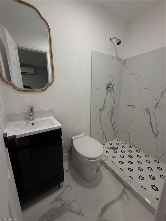 Full bathroom featuring a marble finish shower, vanity, and marble finish flooring