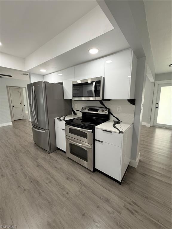 Kitchen with stainless steel electric range, white cabinetry, fridge, modern cabinets, and recessed lighting
