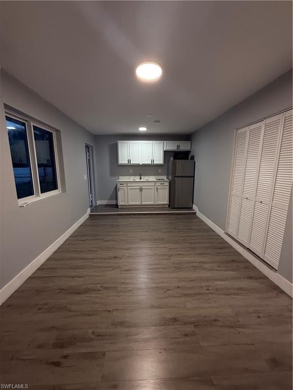 Unfurnished living room featuring dark wood-style floors and recessed lighting