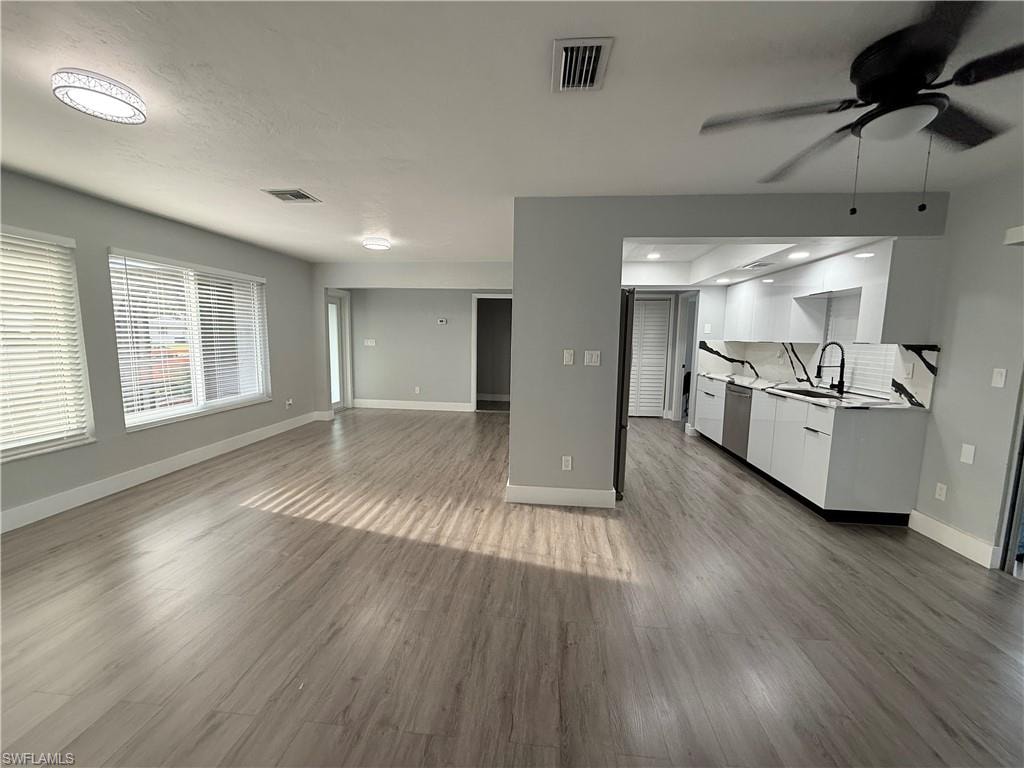 Unfurnished living room featuring a ceiling fan and wood finished floors