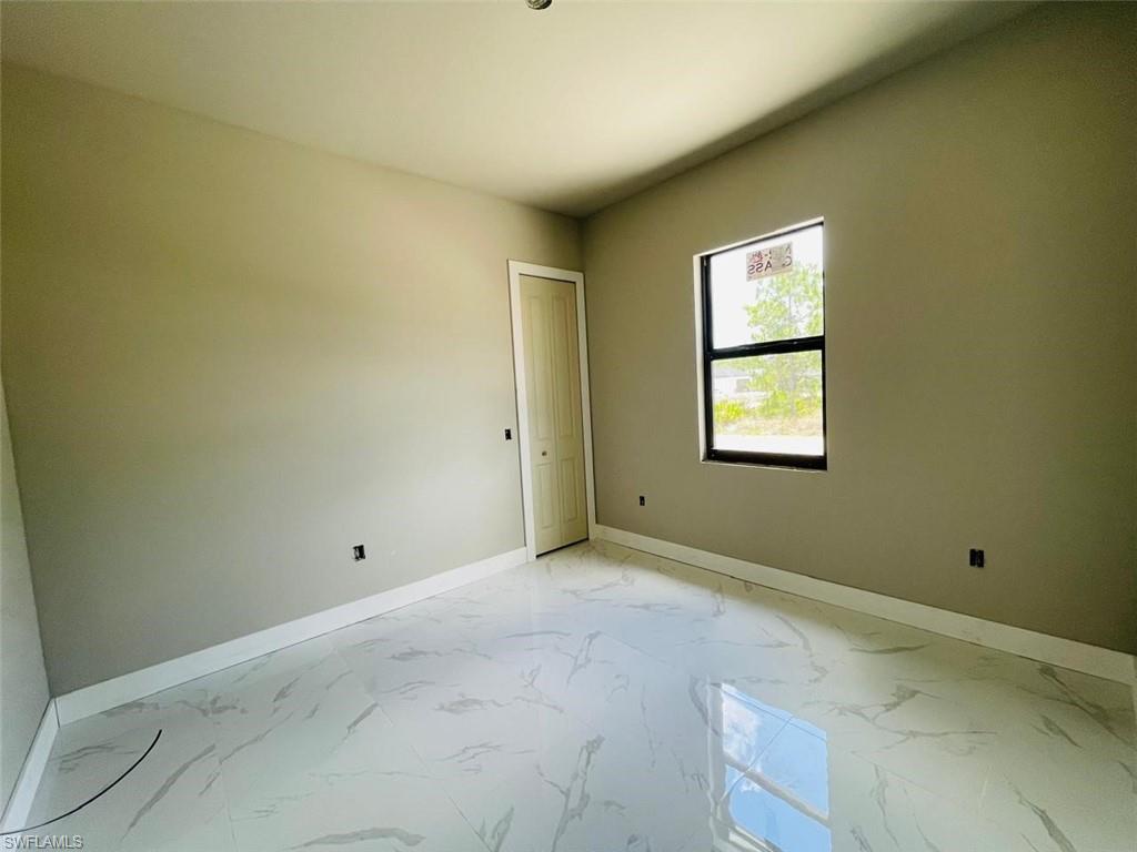 Spare room with baseboards and light marble finish floors