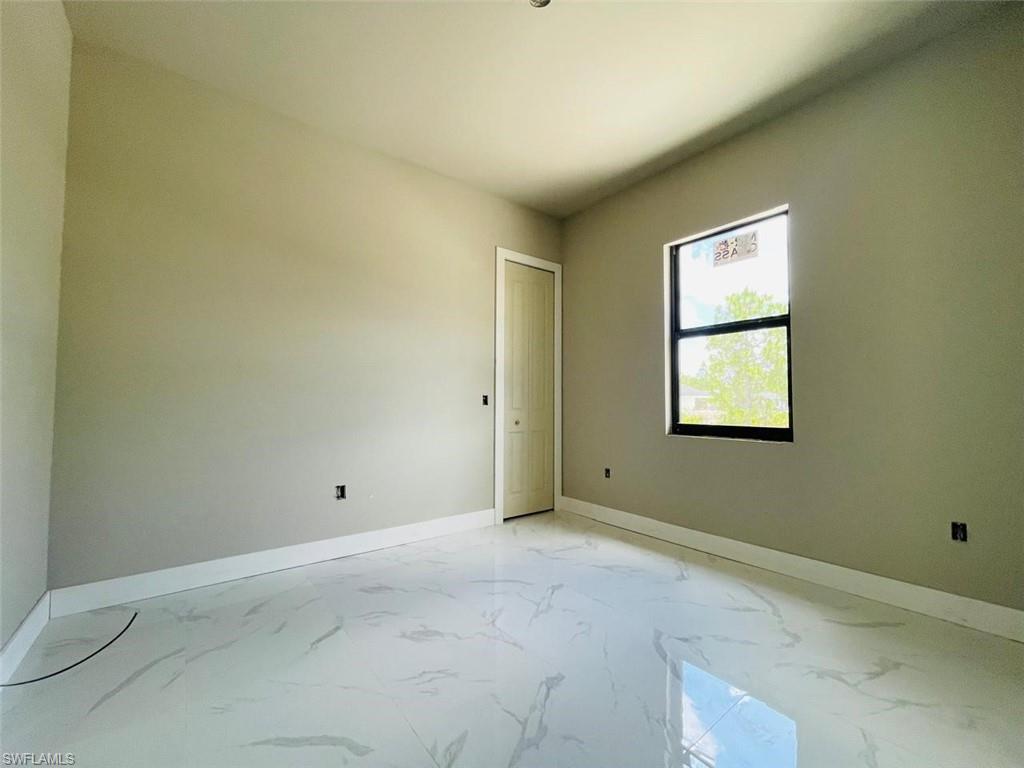 Spare room with baseboards and light marble finish flooring