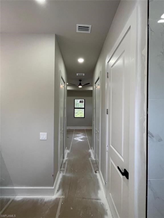 Hallway with baseboards and recessed lighting